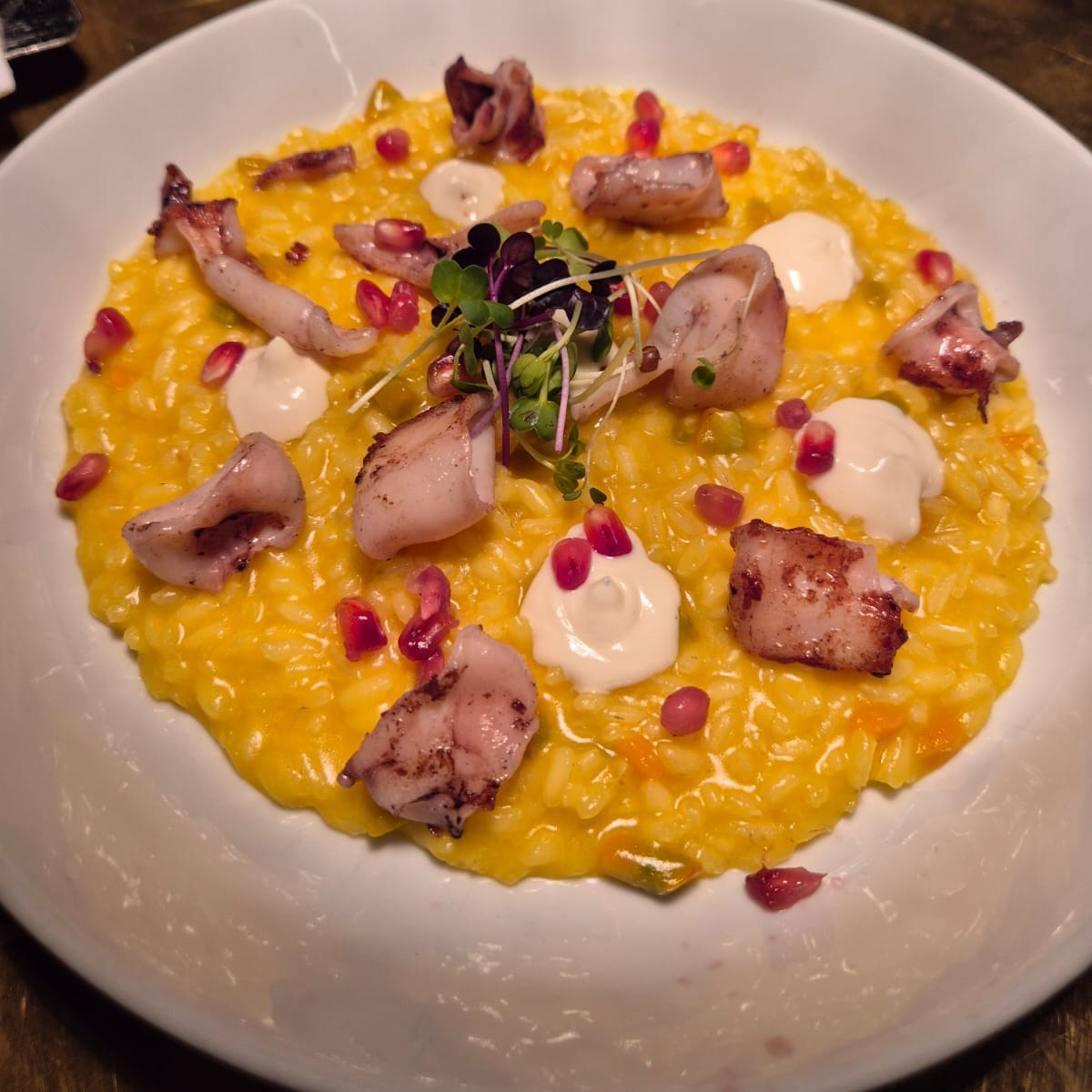 Risotto allo zafferano, calamaretto affumicato, mousse di caprino e melograno Q
